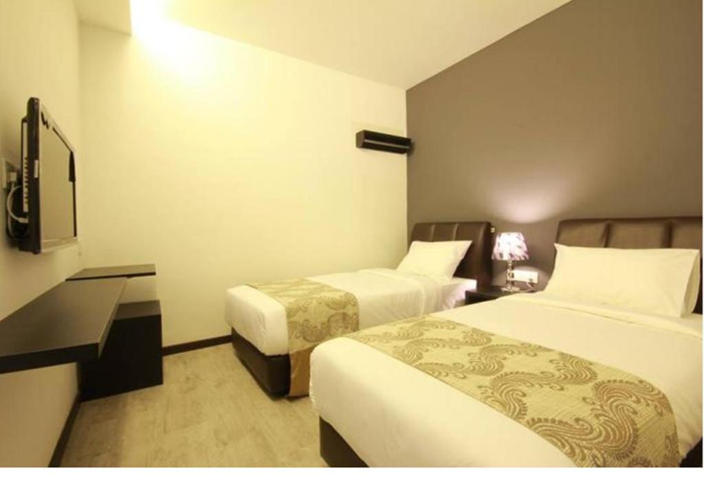 Postel nebo postele na pokoji v ubytování Sandy Hotel Malacca