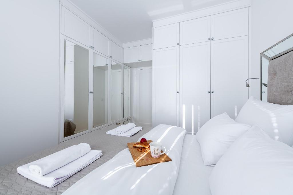 ワルシャワにあるP&O Apartments Aleja Krakowskaの白いベッドルーム(ベッド2台、鏡付)