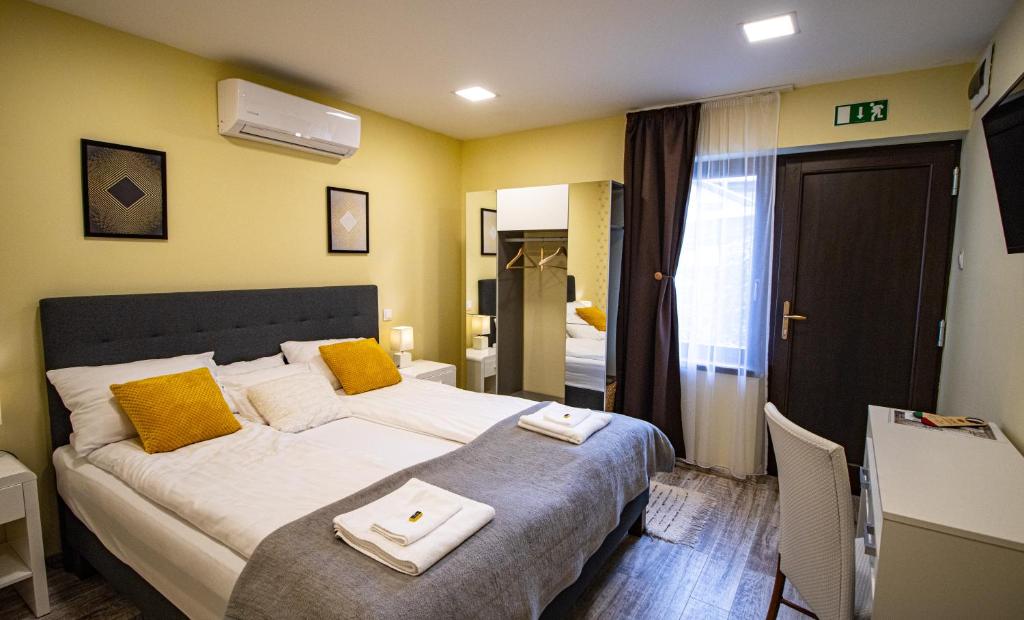 トカイにあるFakapu Pince és Panzióのベッドルーム1室(黄色い壁の大型ベッド1台付)
