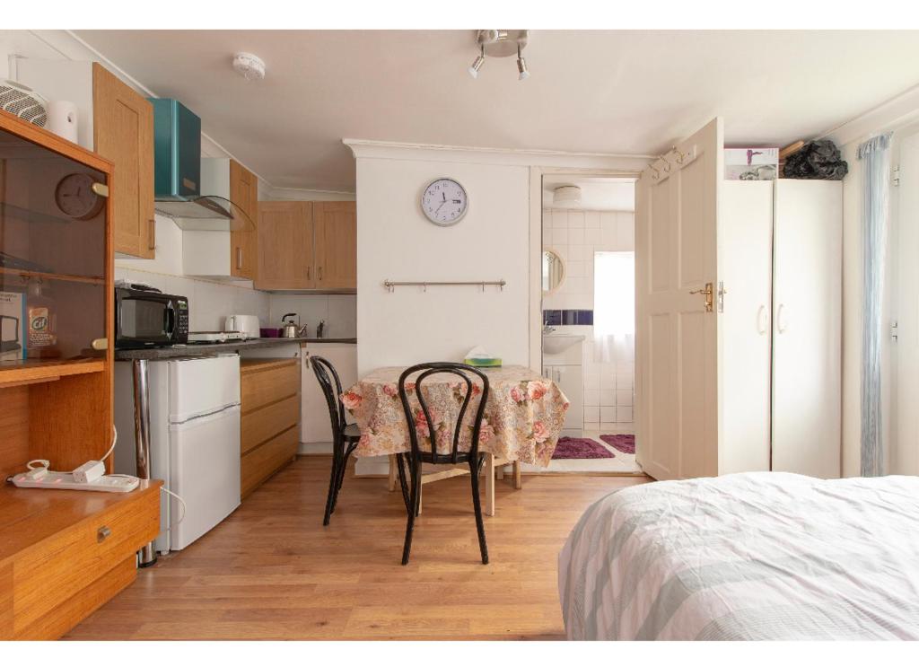 a kitchen with a table and chairs in a room at Quite studio in Hendon