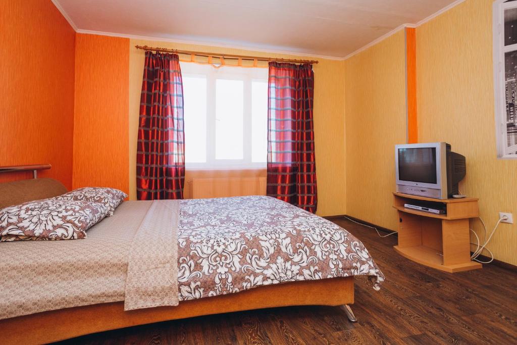 a bedroom with a bed and a television at Apartmens Faraon On Illinskaya New Building 6 floor in Sumy