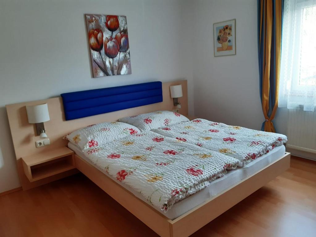 Schlafzimmer mit einem Bett mit blauem Kopfteil in der Unterkunft Ferienwohnung Kerth in Sankt Kanzian am Klopeiner See