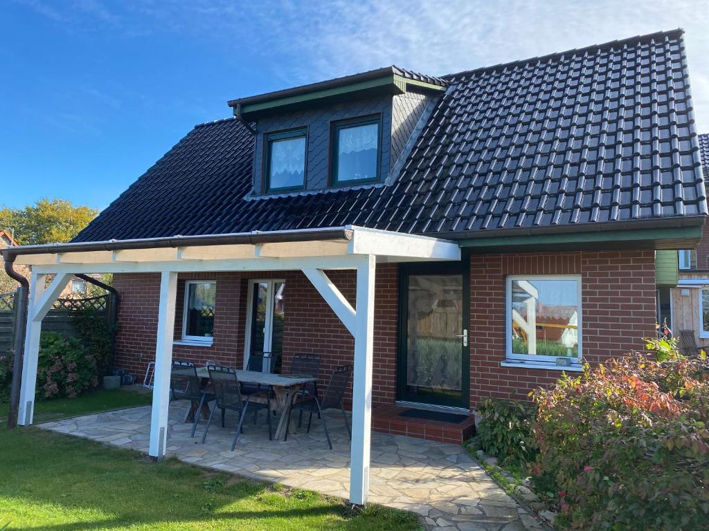 ein Backsteinhaus mit einem Dach und einer Terrasse in der Unterkunft Ferienhaus Kira in Boltenhagen