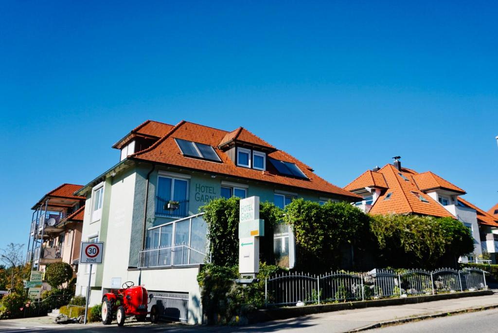 a house with a red roof on a street at Engelberg 24h check in in Wangen im Allgäu