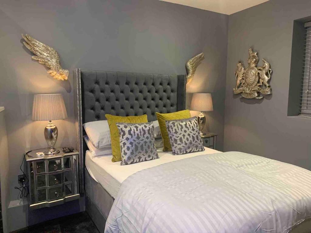 a bedroom with a large bed with yellow and blue pillows at Egremont House - Brighton Rock Rooms in Brighton & Hove