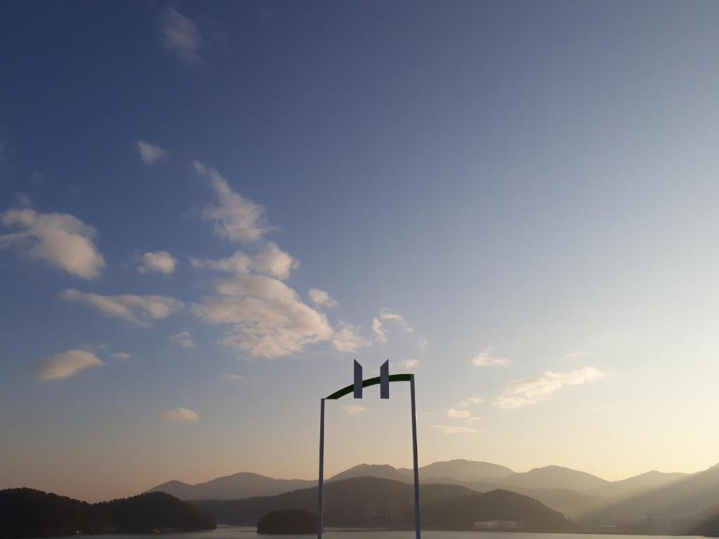 统营市Tongyeong Bridge Hotel的湖中一根杆上的两个十字架