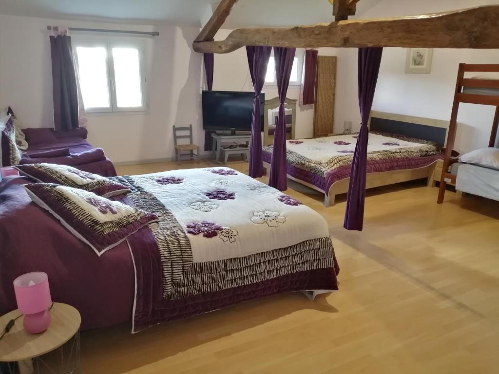 a bedroom with two beds and a chair at les tourterelles in Chabournay