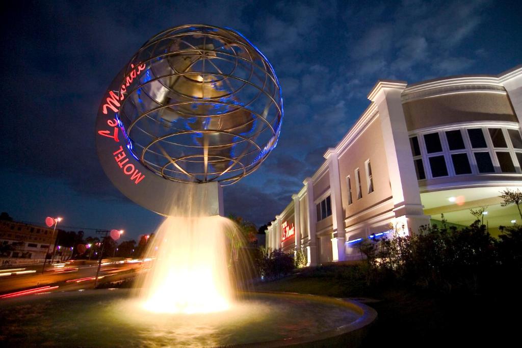 a large sphere sitting on top of a fountain in front of a building at Motel Le Monde (Adult Only) in Belo Horizonte