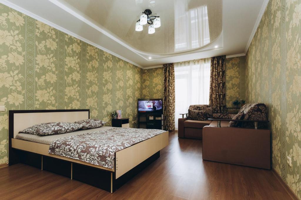 1 dormitorio con 1 cama y TV. en Apartments Faraon neer Manufaktura, en Sumy