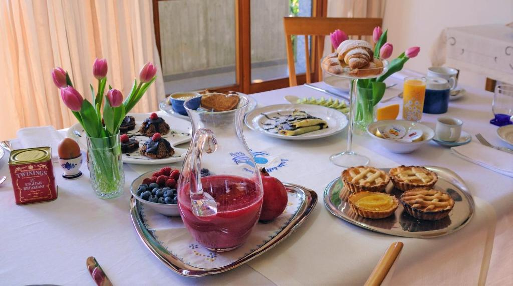 einen Tisch mit Teller mit Speisen und einer Vase in der Unterkunft il nido della dani in Busto Arsizio