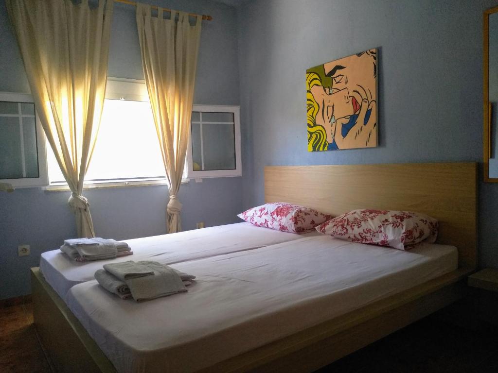 een slaapkamer met een bed met twee handdoeken erop bij House of colors in Néa Meságkala