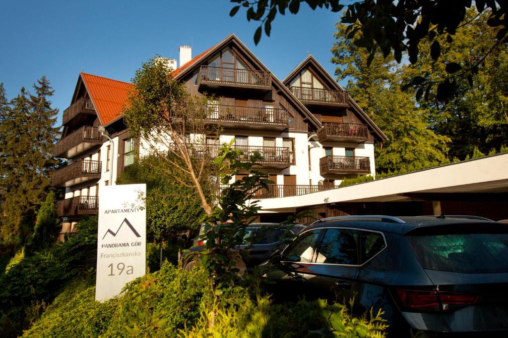 a large building with cars parked in front of it at Apartamentowiec Panorama Gór City Center Family&Pet-friendly in Szklarska Poręba