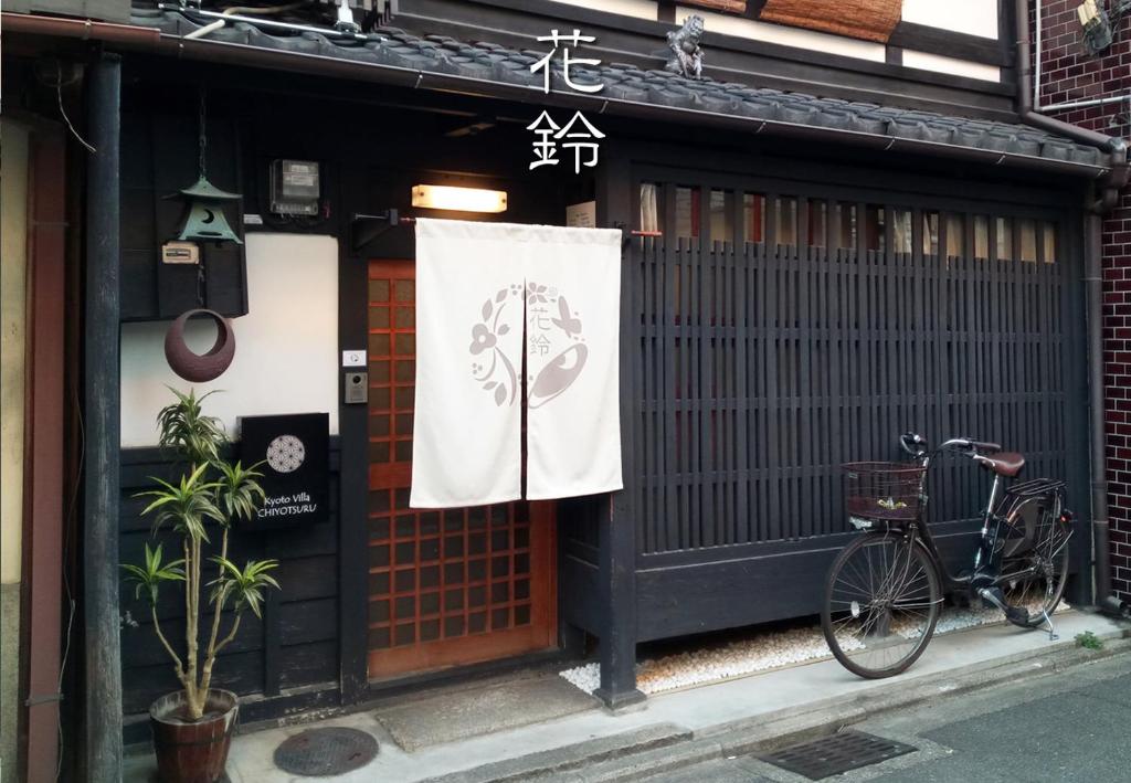 un vélo garé devant un bâtiment avec une porte dans l'établissement Kyoto Villa Chiyotsuru, à Kyoto