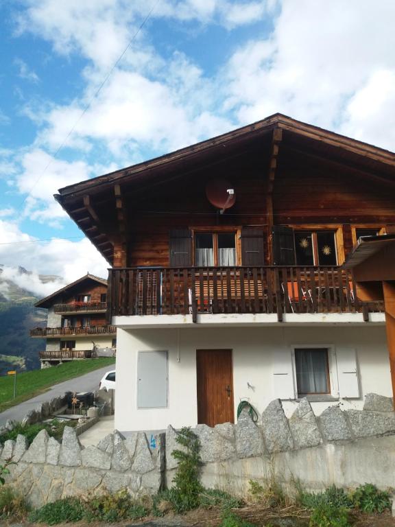 a house in the mountains with a balcony at Chalet Clair de Lune bei Grächen VS in Gasenried