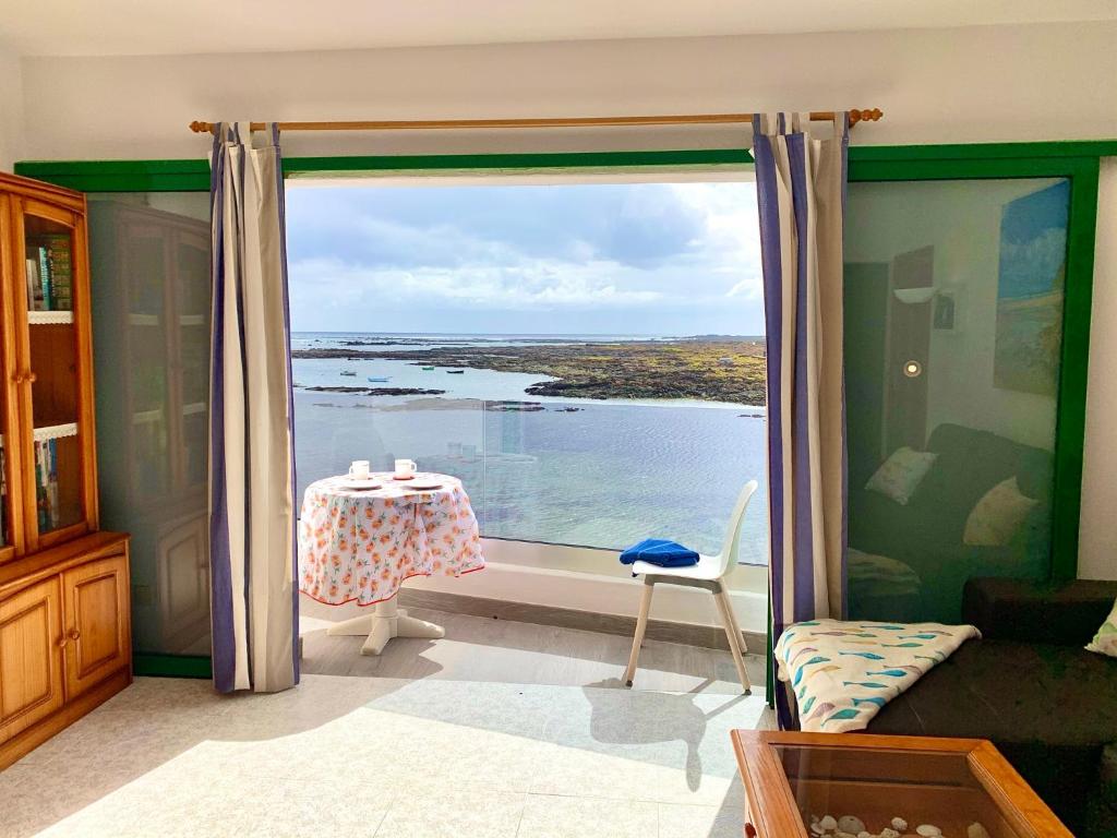 a room with a table and a view of the water at La Playa in Órzola