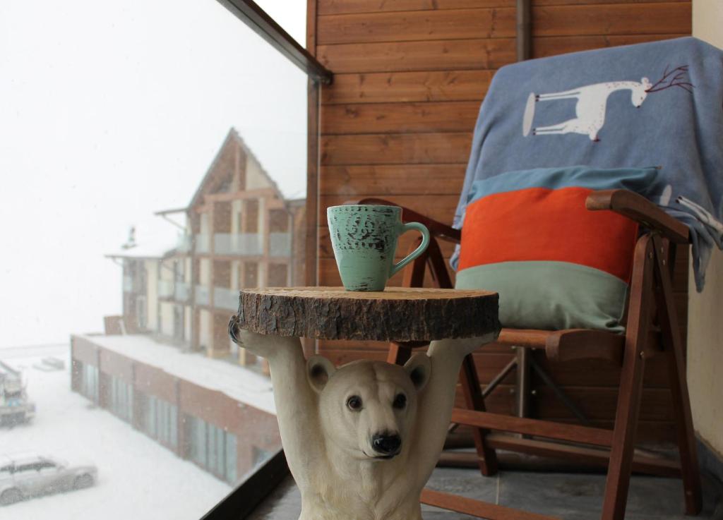 Ein Hund stand unter einem Tisch mit einer Tasse drauf. in der Unterkunft Love Journey Gudauri in Gudauri