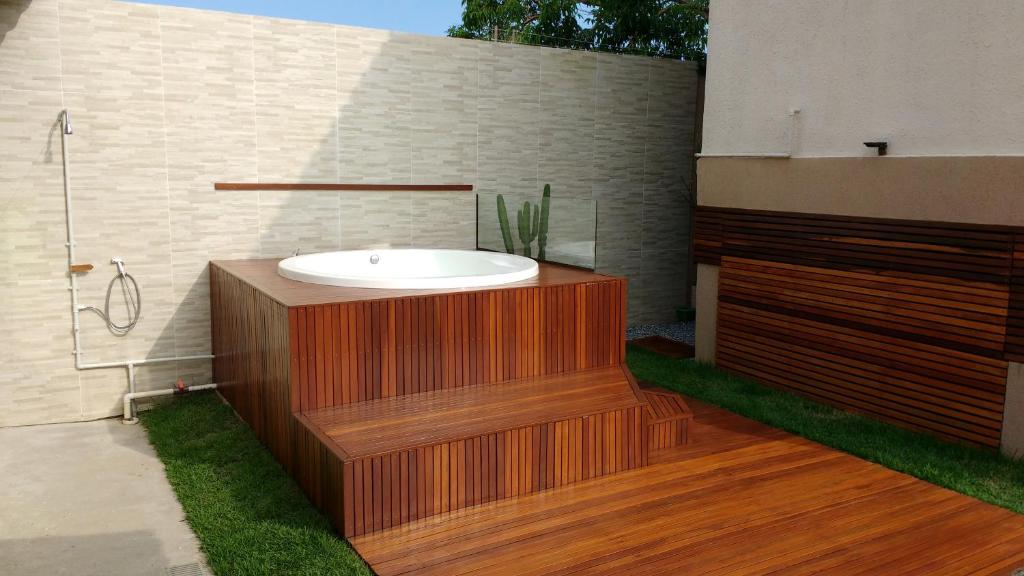 a bathroom with a sink on a wooden deck at casa spa in Rio das Ostras