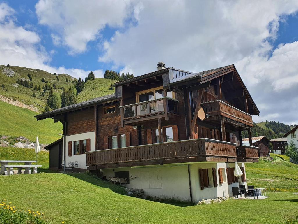 a large wooden house with a balcony on a hill at Apartment Alouette Riederalp in Riederalp