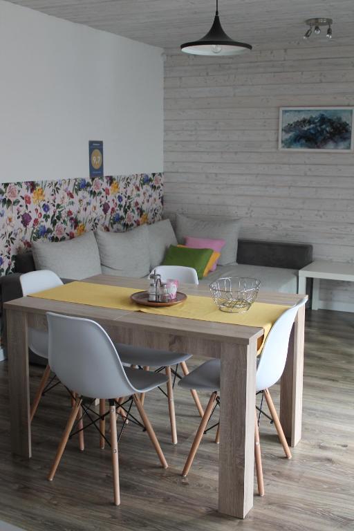 a dining room table with chairs and a couch at Malina - AND Apartment in Liptovský Mikuláš