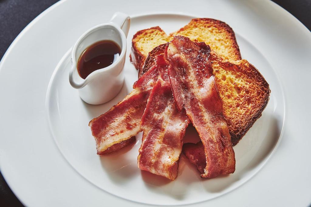 a plate of bacon and toast with a cup of syrup at No.26 By The Sea in Oban