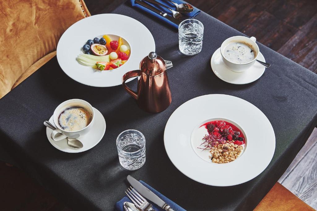 a table with plates of food and cups of coffee at No.26 By The Sea in Oban