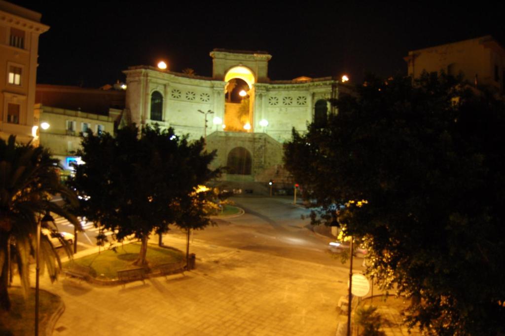 a large white building with a clock tower at night at B&B St. Remy in Cagliari