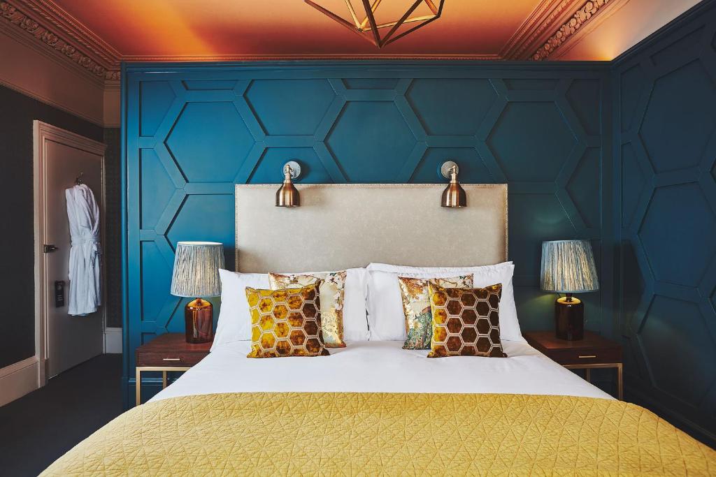 a bedroom with a bed with a blue wall at No.26 By The Sea in Oban
