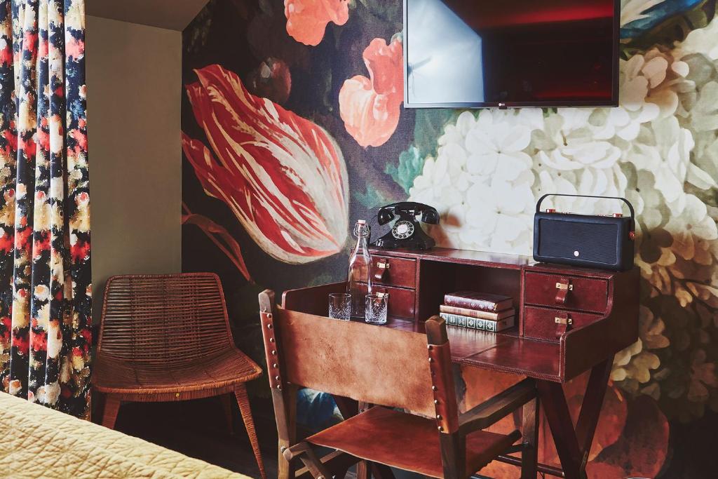 a desk in a bedroom with a painting on the wall at No.26 By The Sea in Oban