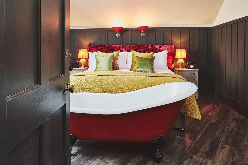 a bedroom with a large bed with a red headboard at No.26 By The Sea in Oban
