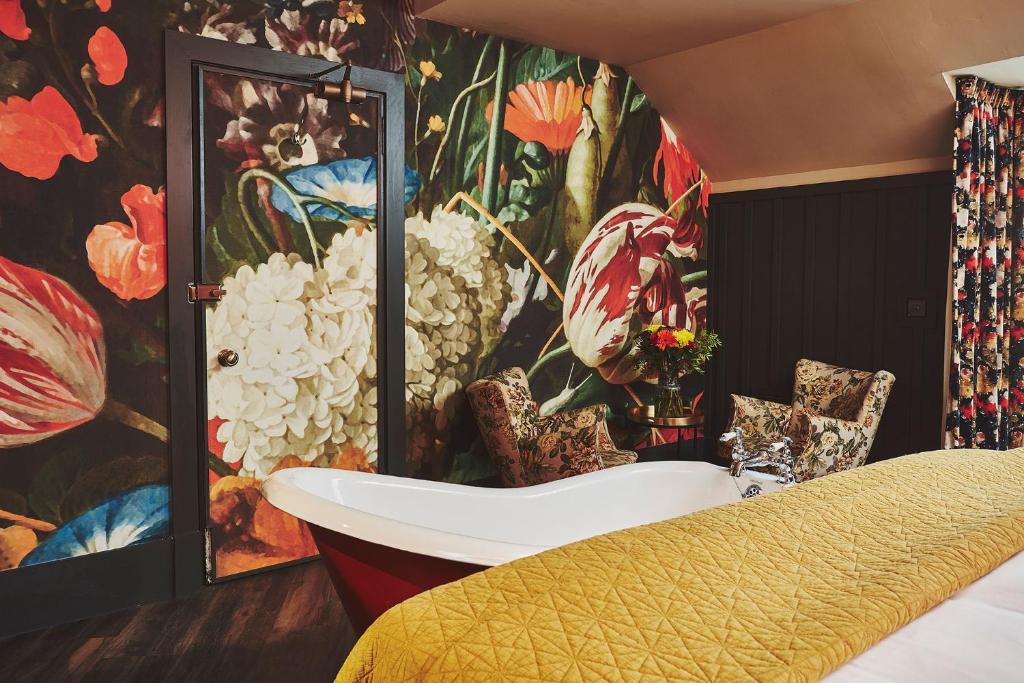a bedroom with a wall mural of flowers and a tub at No.26 By The Sea in Oban