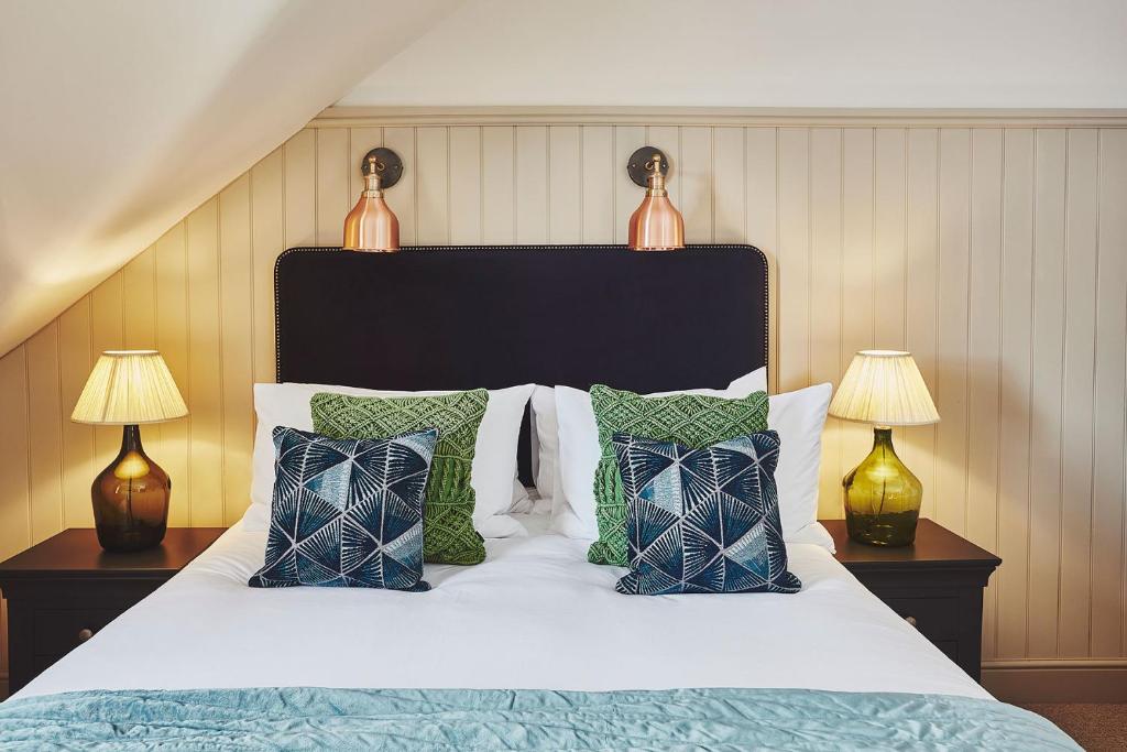 a bedroom with a bed with pillows and two lamps at No.26 By The Sea in Oban
