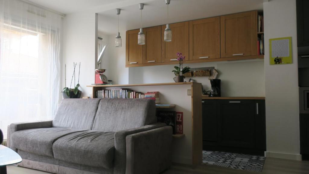 a living room with a couch and a kitchen at Aligre in Paris