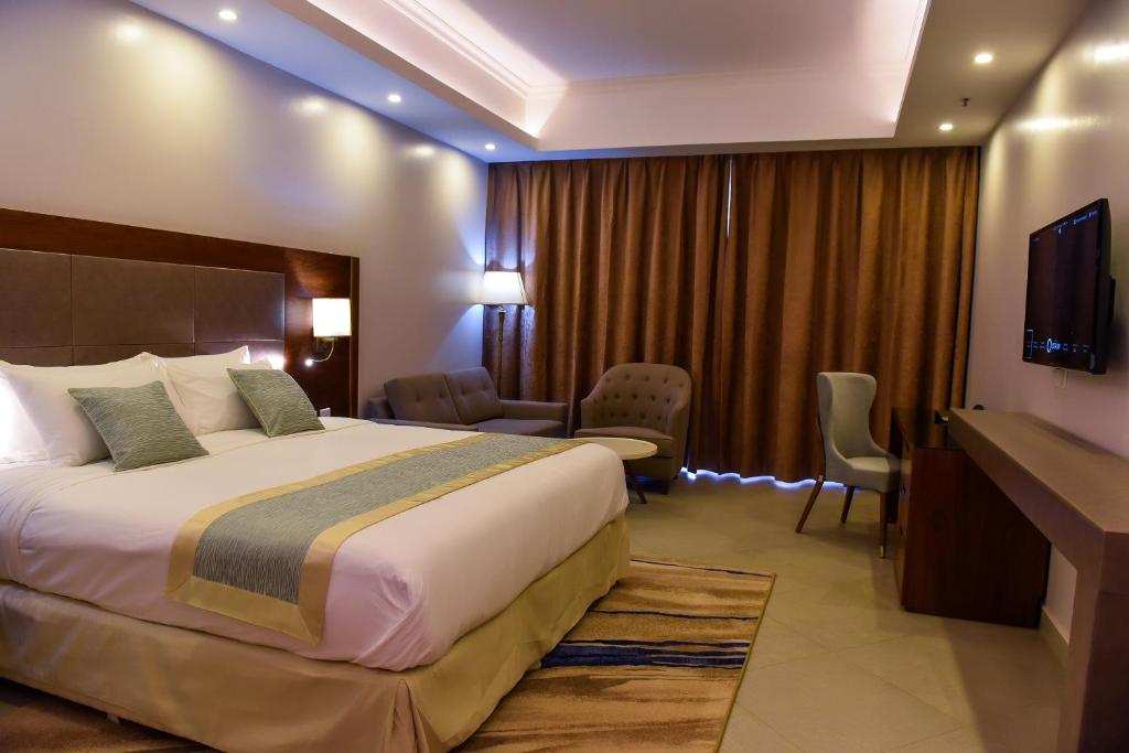 a hotel room with a bed and a television at Admas Grand Hotel in Entebbe