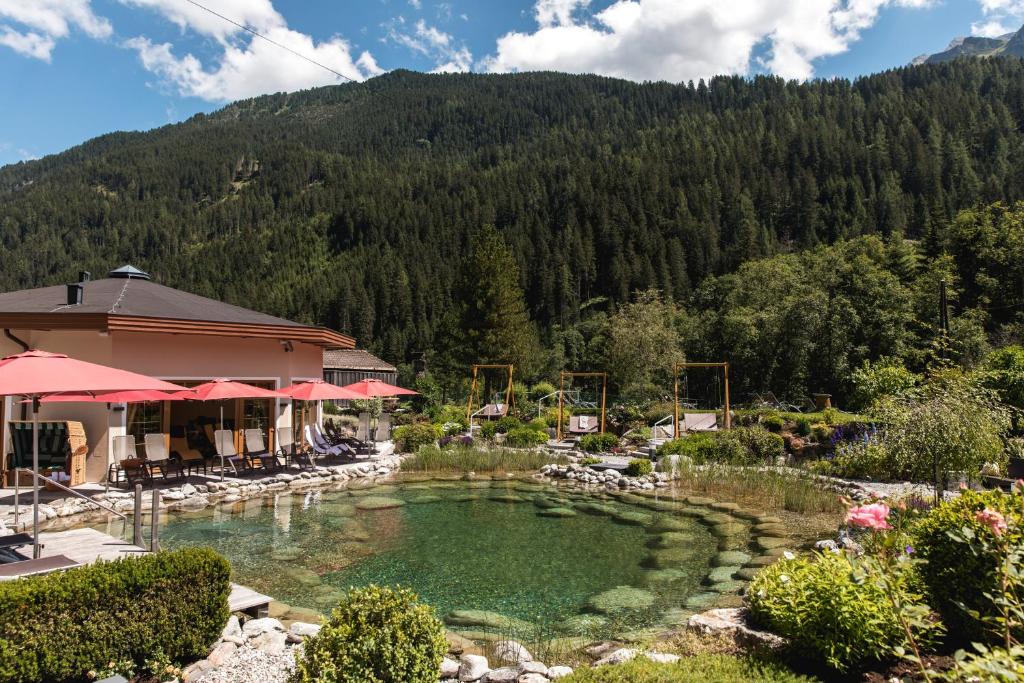 a resort with a pool of water in front of a mountain at Hotel Eden in Tux