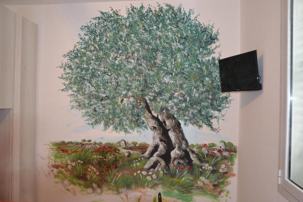 un quadro di un albero su un muro di IL VECCHIO ULIVO a Cutrofiano