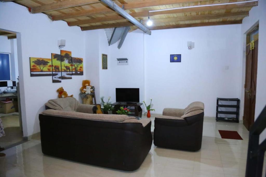 uma sala de estar com dois sofás e uma televisão em White house em Nuwara Eliya