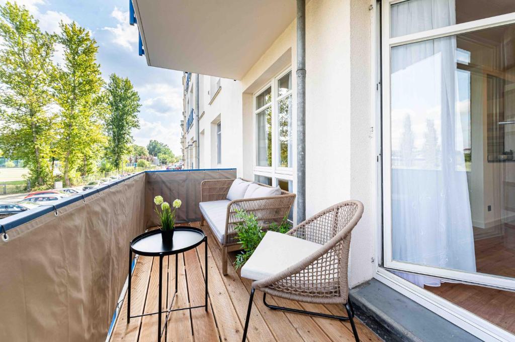 a balcony with two chairs and a table and a window at Apartment Elbkiez - Wohnen zwischen Elbe & Altstadt, stilvoll mit Balkon! in Dresden