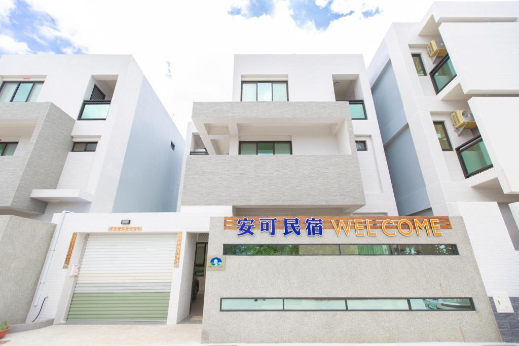 un bâtiment avec un panneau de bienvenue devant lui dans l'établissement Anco Homestay, à Huxi