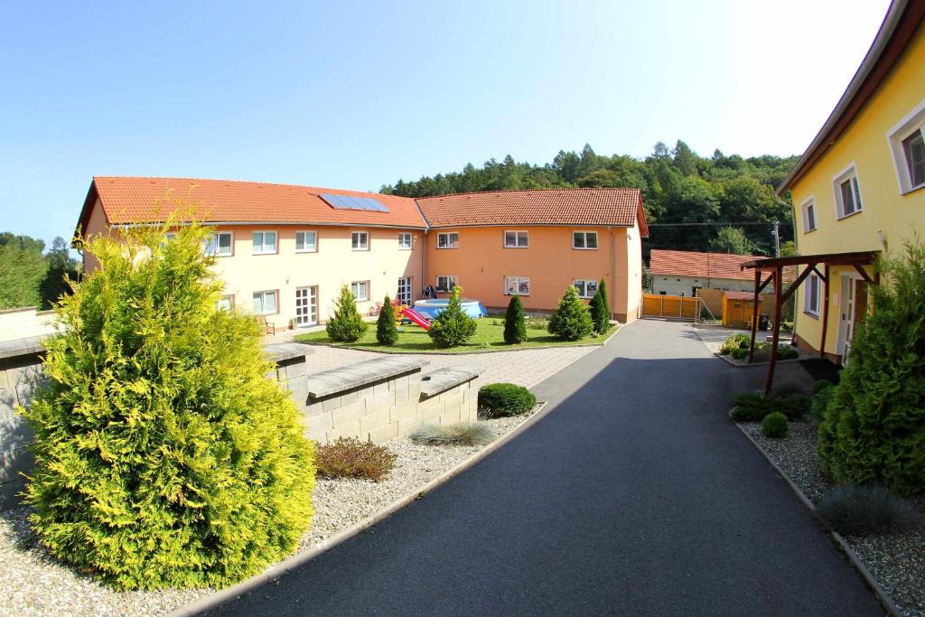 una pasarela en un patio con casas y árboles en Černý Kocour Apart hotel en Šarovy