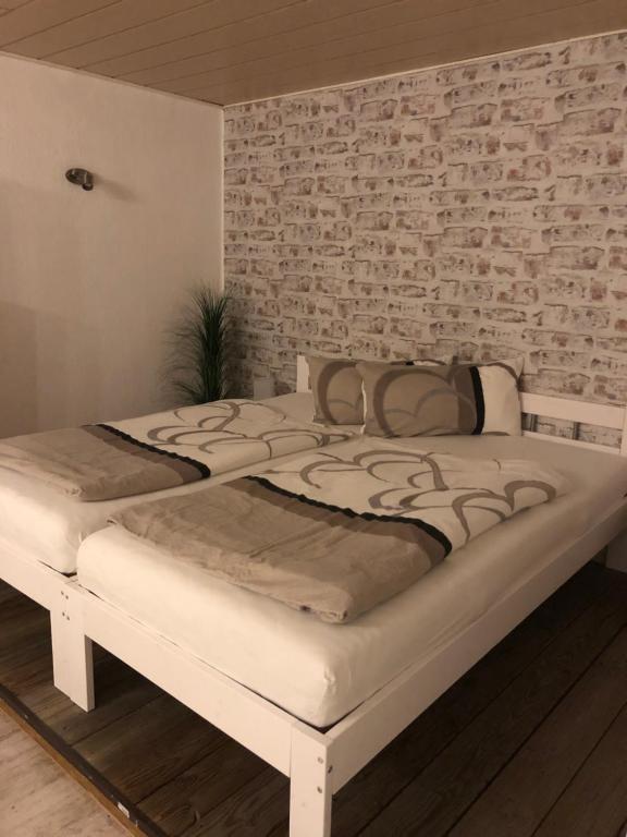 a bedroom with two beds in front of a brick wall at Apartment 4you in Eggolsheim