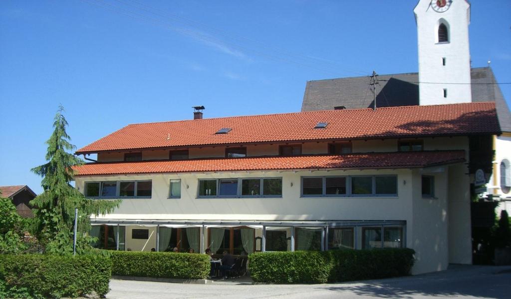 un edificio con una torre dell'orologio sopra di Gasthaus Kellerer a Raubling