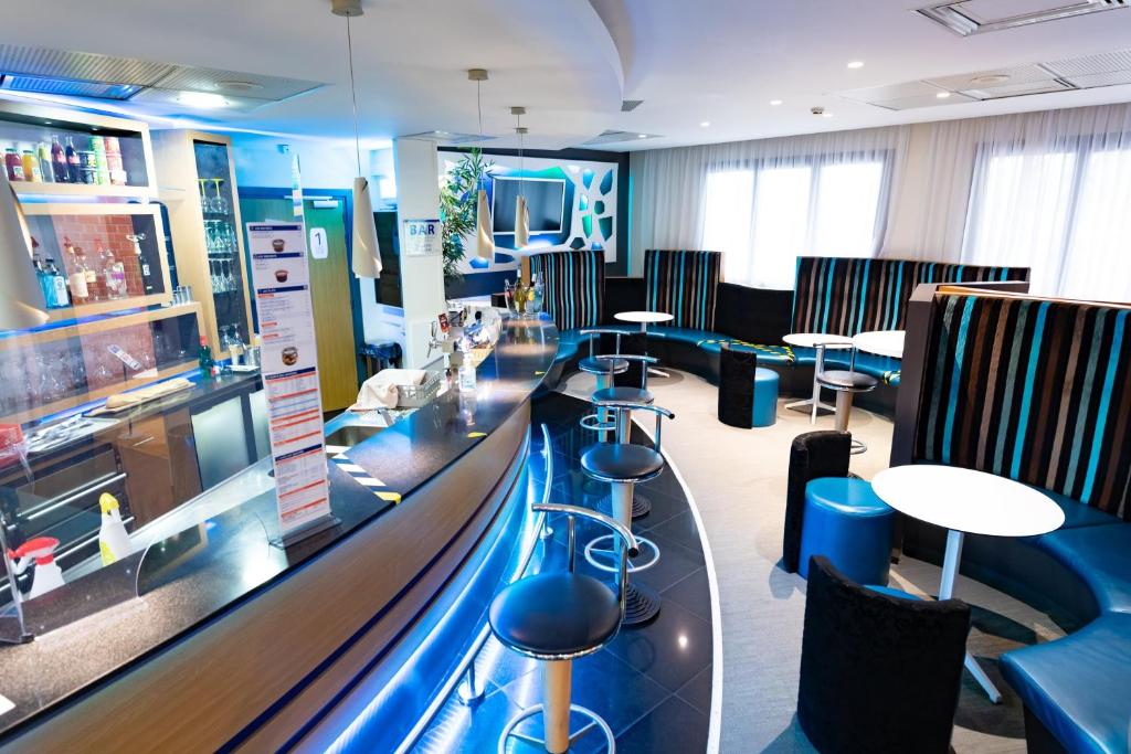 a bar in a restaurant with stools and tables at Holiday Inn Express Arras, an IHG Hotel in Arras