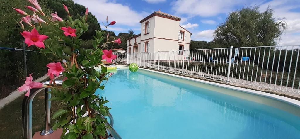 une piscine avec une clôture et un bâtiment dans l'établissement La Cascadeta, à Marignac-Lasclares