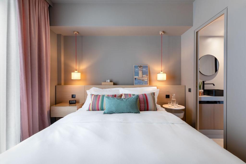 sypialnia z dużym białym łóżkiem z 2 poduszkami w obiekcie Central Athens Penthouse w Atenach