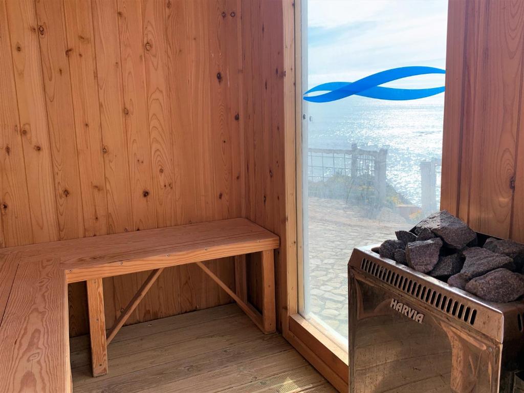 a sauna with a bench next to a window at Villa Ana Margarida Beach in Ericeira