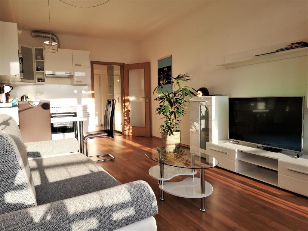 a living room with a large television and a table at New apartment with garage parking in Brno