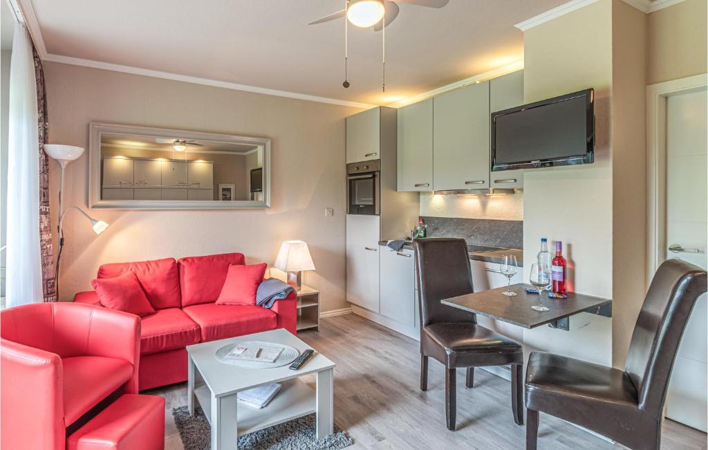 - un salon avec un canapé rouge et une table dans l'établissement Amazing Apartment In Friedrichskoog With Kitchen, à Friedrichskoog