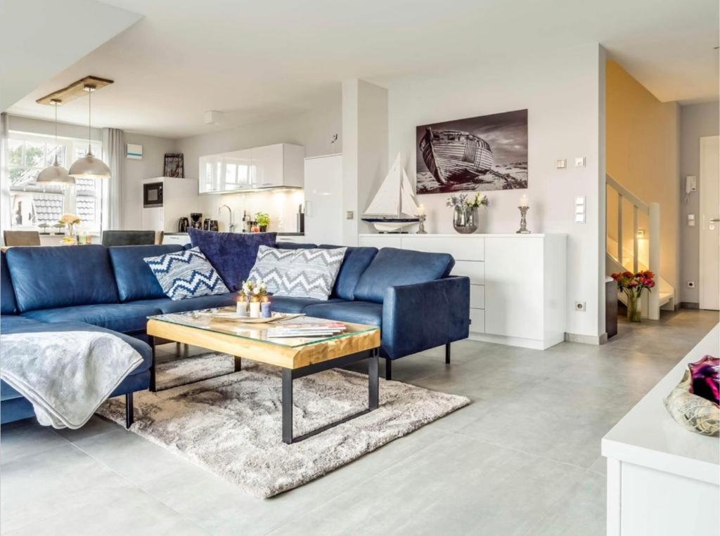 ein Wohnzimmer mit einem blauen Sofa und einem Tisch in der Unterkunft Haus MEERLE in Zingst