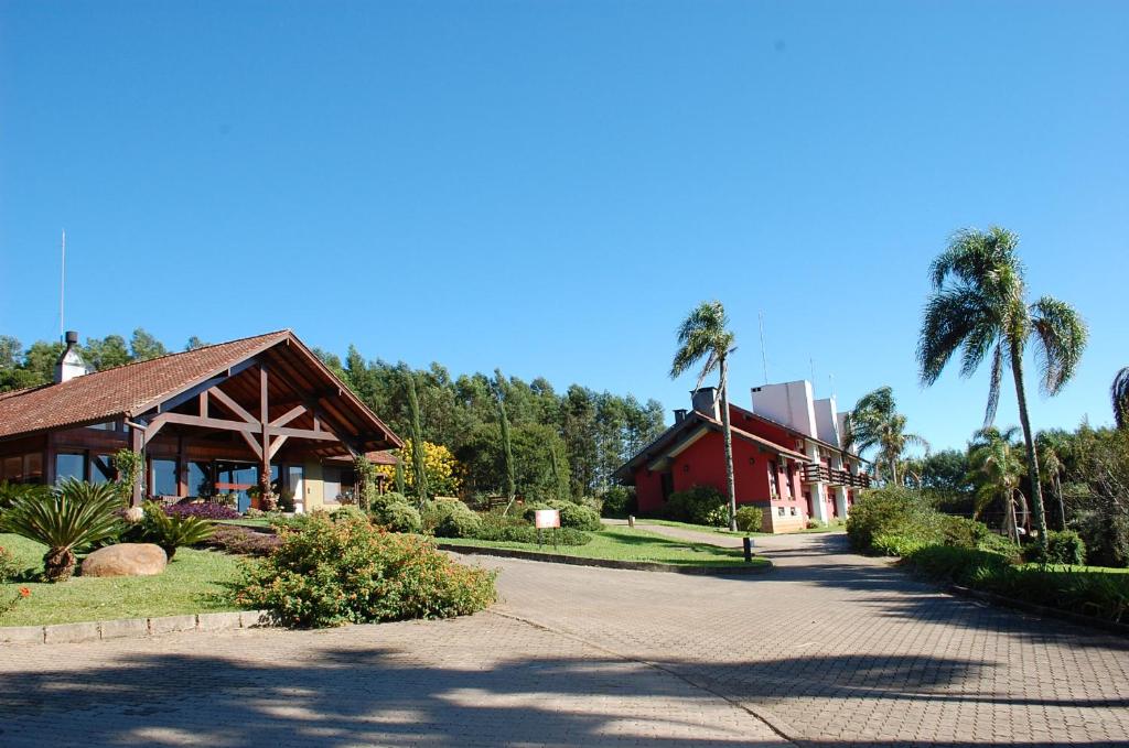 a building with palm trees next to a road at Hotel Vila Verde in Nova Petrópolis