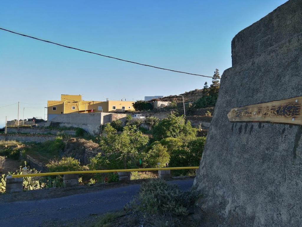 a sign on the side of a wall next to a road at GREEN VILLAGE. TONY FRÍAS. in Fasnia